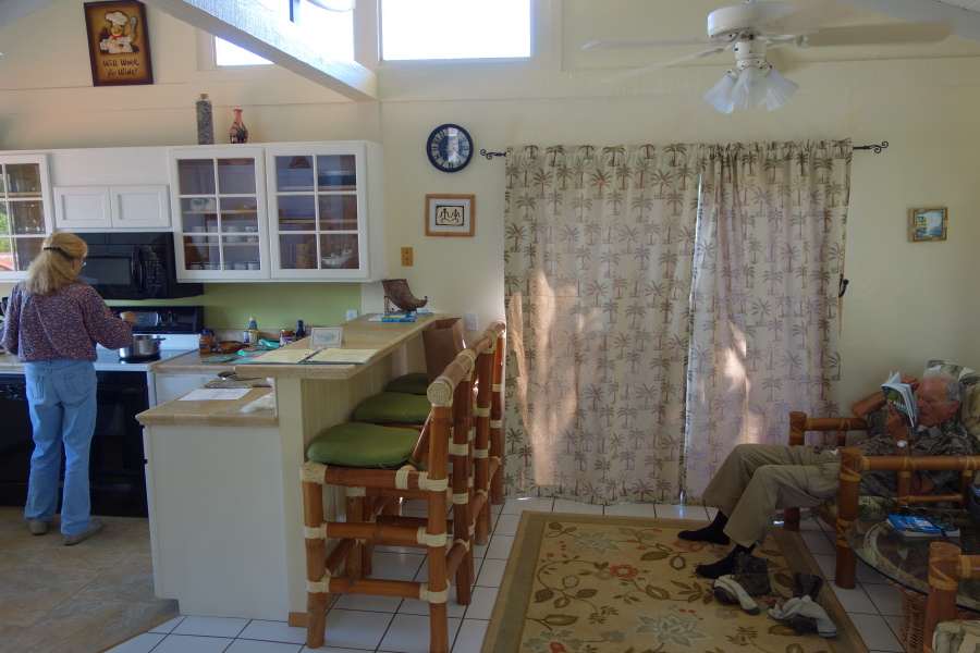 Kay makes soup while David reads a guide book to the island.