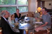 David and Bill prepare to eat oatmeal while Laura works on her laptop.
