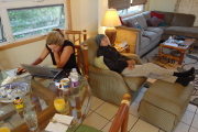 Laura buries herself in her laptop while David relaxes in coat and cap.