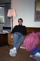 Bill sits on the couch.