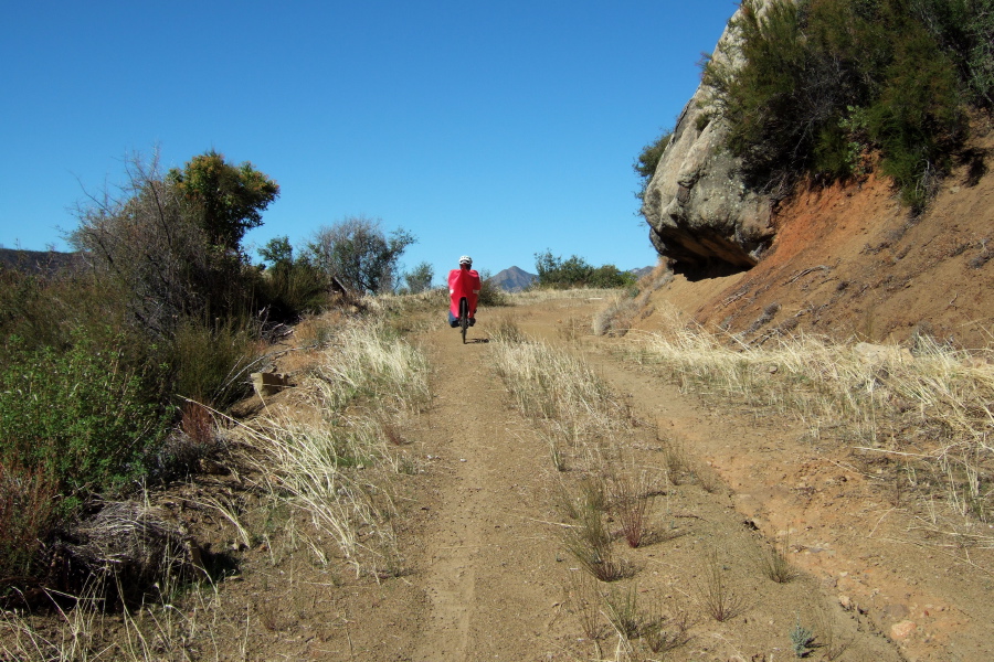 Ron rides past a nose-like rock.