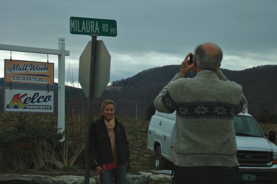 Laura poses in front of the sign for Milaura Road.