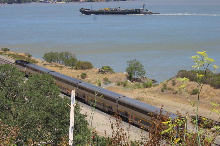 An Amtrak Capitol goes by below the road.