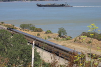 An Amtrak Capitol goes by below the road.