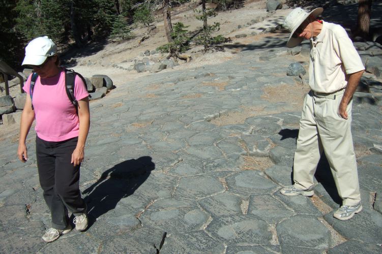 Stella and David walk atop the Postpile.