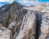We reach a narrow spot on the ridge that requires crossing a deep notch, then continuing atop a narrow arete.