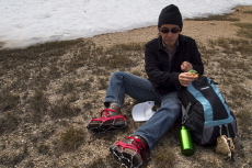 Stella straps on her spikes and eats a snack before tackling the snowfield.