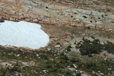 David leans against his rock at the base of the snowfield, as seen from Echo Ridge (11168ft).