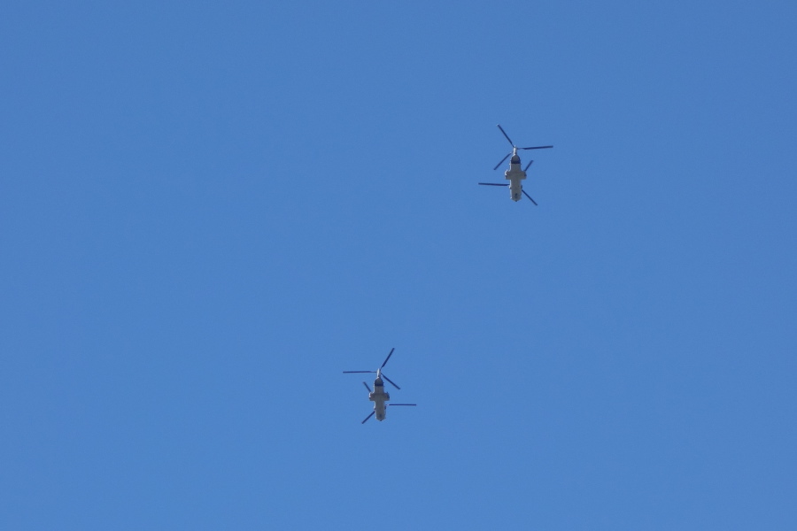 Transport helicopters pass overhead.