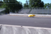 Bill rides the wrong way down the track to the starting line.
