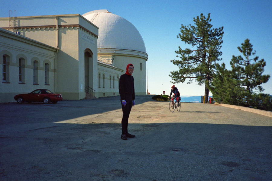 Bill tries to keep warm while Thomas Maslen arrives at the summit.