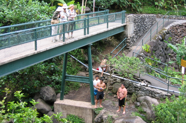 Local kids jump off the rock into a deep pool below.