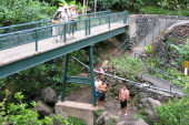 Local kids jump off the rock into a deep pool below.