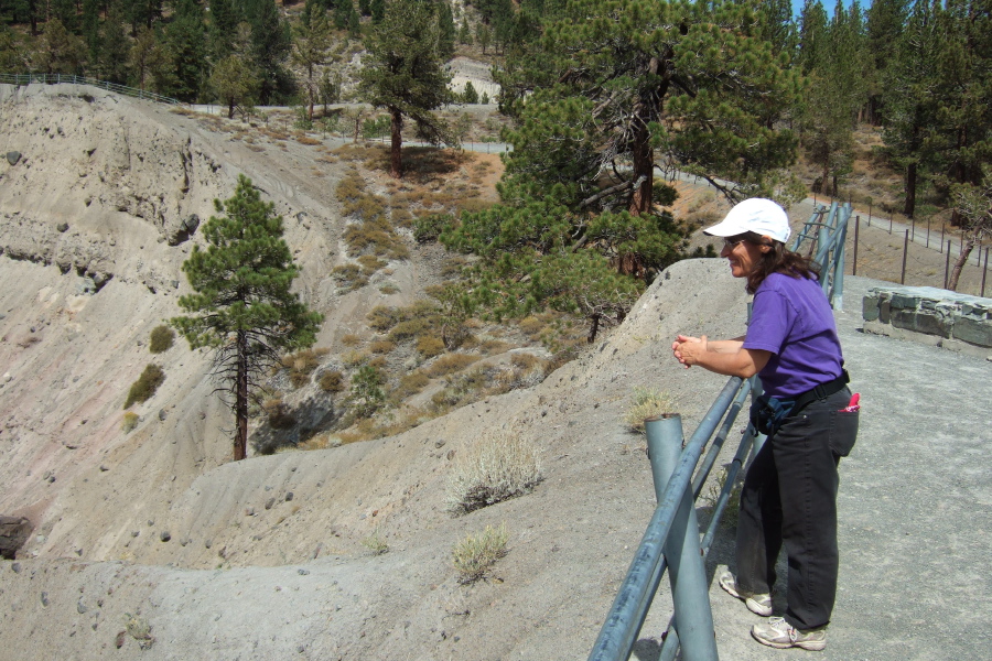 Stella stands at the crater rim.