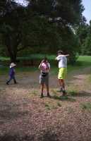 Jude takes a swing while Jennifer photographs the photographer.