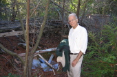 David examines the ruins of an old subfloor of a building and broken glass.