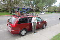 Zach stands next to Lee's Bike Van, side view.