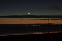 The waxing crescent follows the sun over the horizon.