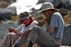 Marc pumps water from Deer Lake while Bill wipes the mosquitos off his arm.