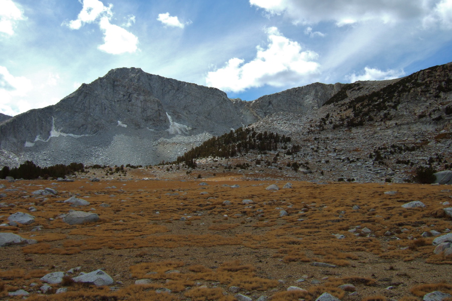 Crossing a large meadow near Kuna Lake below Kuna Crest and Mammoth Peak