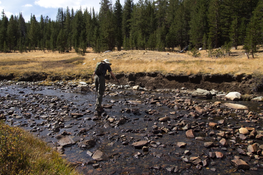 Bill crosses Parker Pass Creek on tippy stones.