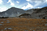 Crossing a large meadow near Kuna Lake below Kuna Crest and Mammoth Peak