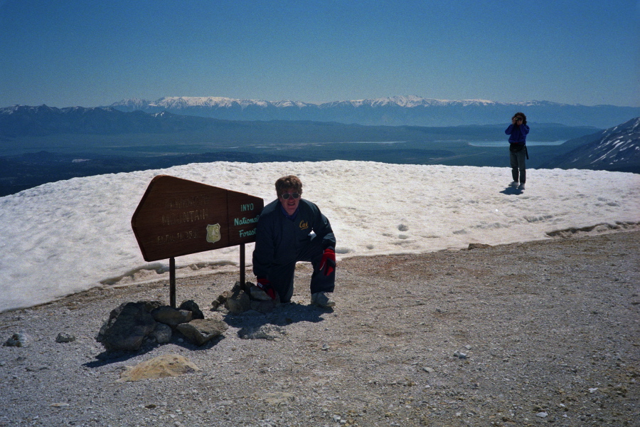 Chris at the summit marker; Stella takes a photo.