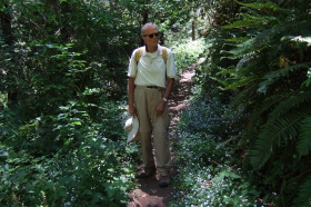 David pauses on the trail next to some houndstongue (flowers).