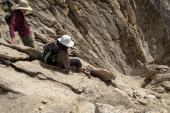 Stella downclimbs the crux, taking care not to slide into the abyss.