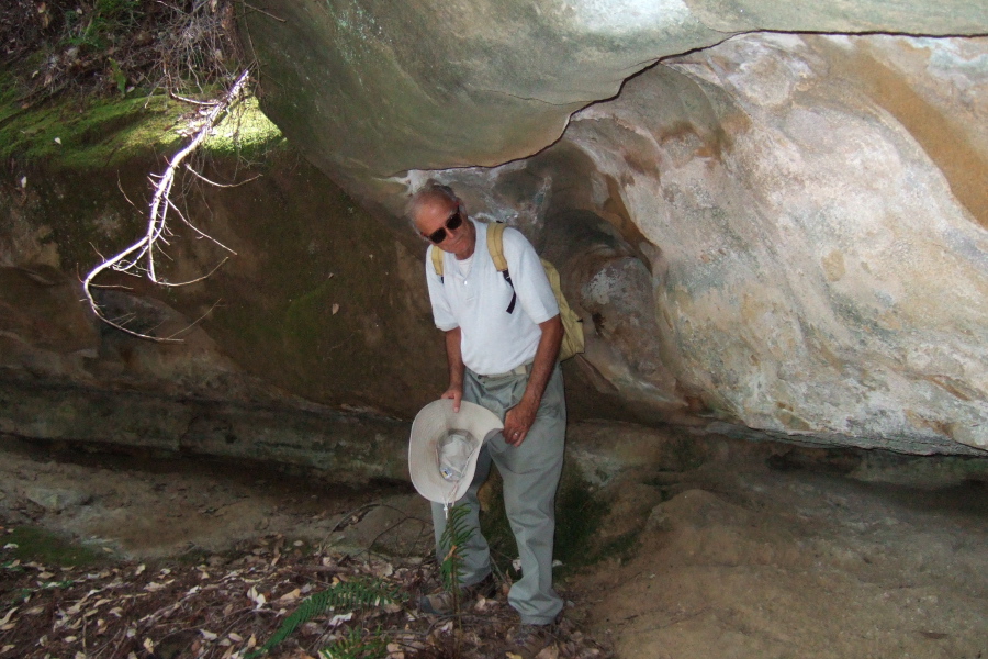 David stands under the sandstone rock.