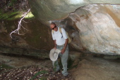 David stands under the sandstone rock.