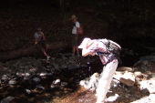 David soaks his hat in Peters Creek while Alice and Ron look on.
