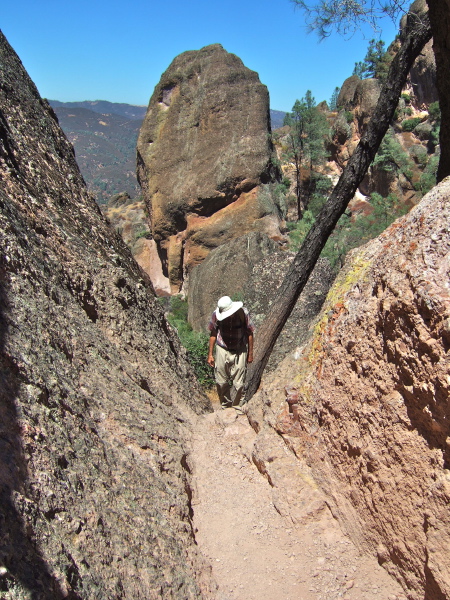 David climbs up between two rocks.