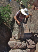 David uses sticks to help with balance when descending the large stone steps.