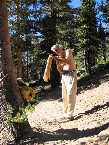 David wrings out his soaking clothes.