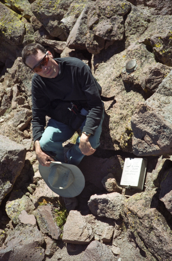 Bill at the benchmark and summit register of San Joaquin Mountain
