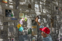 Ron gives a high five to a hand on the memorial wall at the end of the Seacliff RV park.