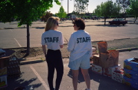 Carol Madsen and Hildy Licht distribute food.