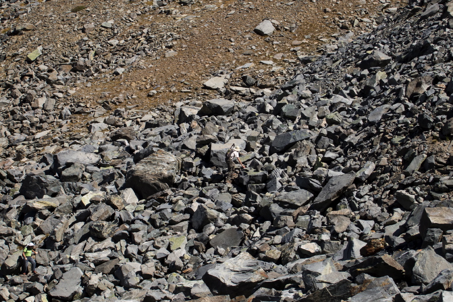 Stella and Bill scramble through the talus, aiming for the brown grassy area to the left.
