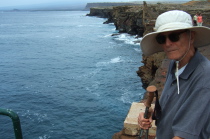 David stands atop the cliff at the water's edge.
