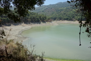 A rope swing hangs unused over the low water.