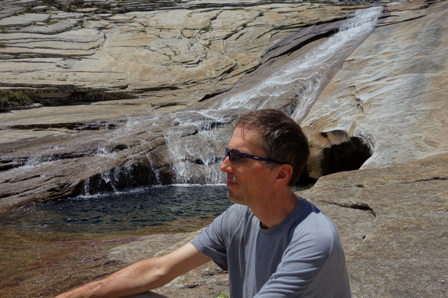 Bill sits by the water's edge.