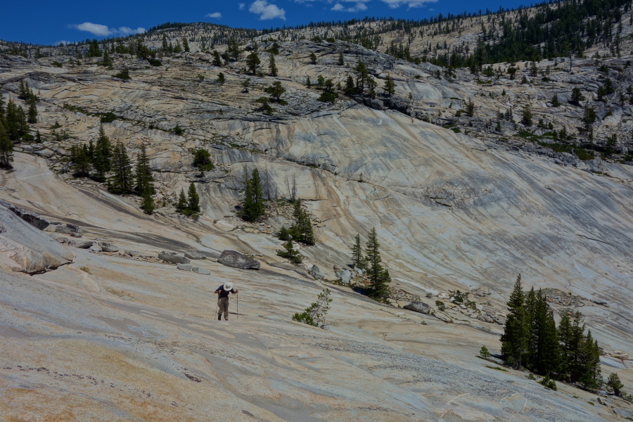 David climbs the steeper slabs of the dome next to the cascade.