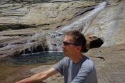Bill sits by the water's edge.