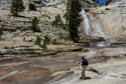 David stands beside the water running over the slabs.